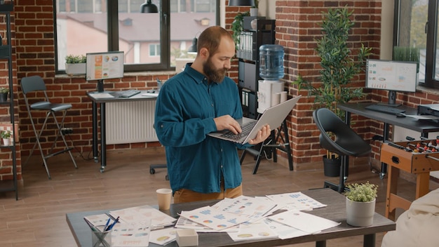 Homem de negócios se sentindo feliz com a vitória do projeto bem-sucedido, lendo notícias no laptop. Funcionário realizado desfrutando de triunfo e objetivo após assinar contrato, sentindo-se ambicioso em relação à carreira