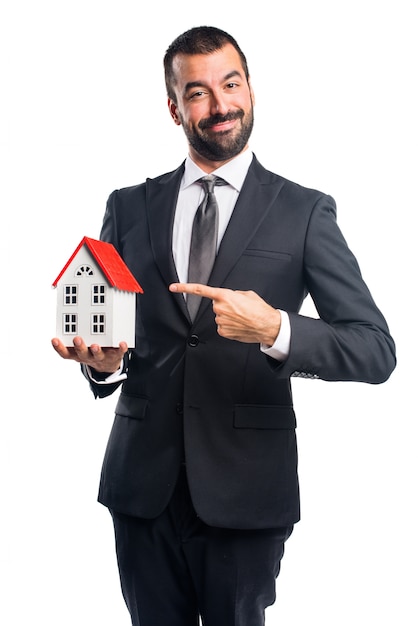 Homem de negócios segurando uma casa pequena