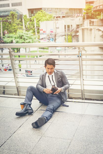 Homem de negócios sentado no chão estressado.