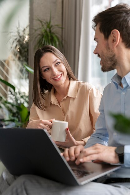 Homem de negócios sorridente e mulher trabalhando juntos no escritório com um laptop