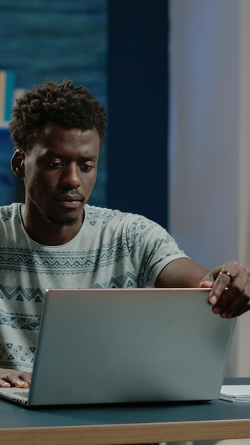 Foto grátis homem de negócios trabalhando em casa com laptop na mesa. empreendedor usando dispositivo moderno para trabalho remoto online na conexão com a internet. trabalhador profissional fazendo projeto com gadget