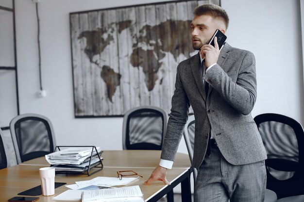 Homem de negócios trabalhando no escritório. Homem está falando ao telefone. Homem de terno.