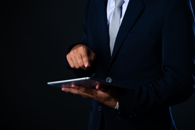 Foto grátis homem de negócios usando tablet analisando dados de vendas e gráfico de crescimento econômico, tecnologia