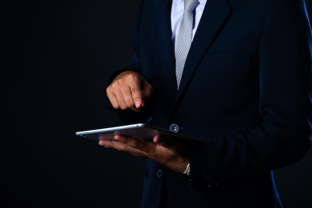 Homem de negócios usando tablet analisando dados de vendas e gráfico de crescimento econômico, tecnologia