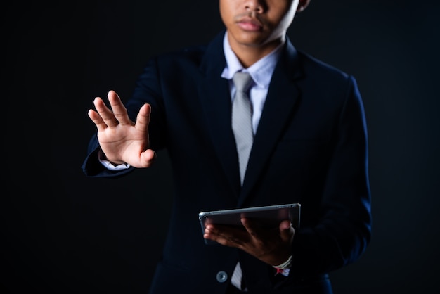 Homem de negócios usando tablet analisando dados de vendas e gráfico de crescimento econômico, tecnologia