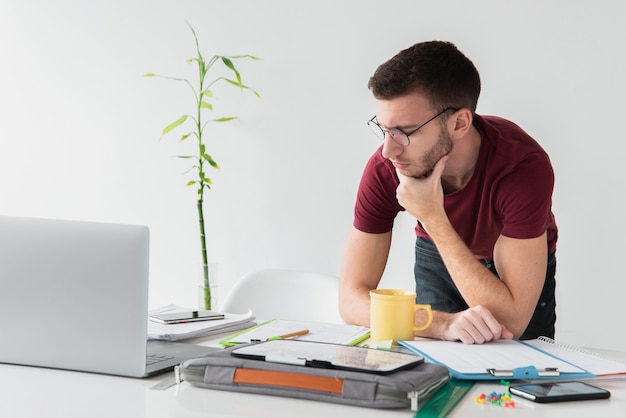 Homem de pé em sua mesa e desviar o olhar