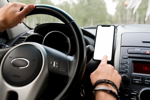 Homem de pé no banco do motorista usando o telefone