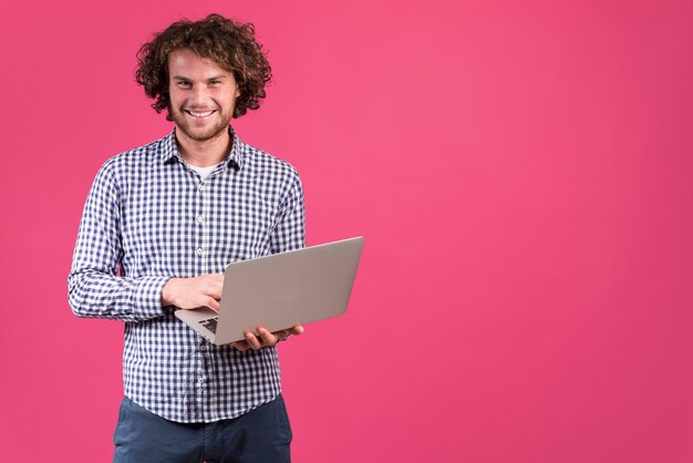 Homem de pé usando laptop