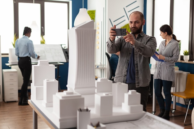 Foto grátis homem de profissão de arquiteto olhando para o layout da maquete