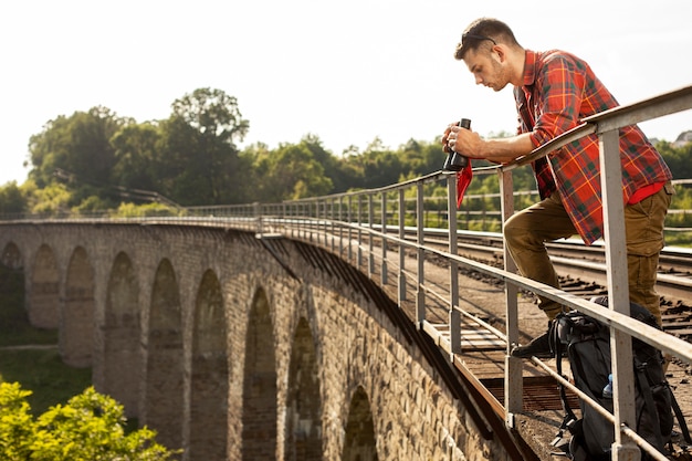 Foto grátis homem de retrato na ponte com binóculo