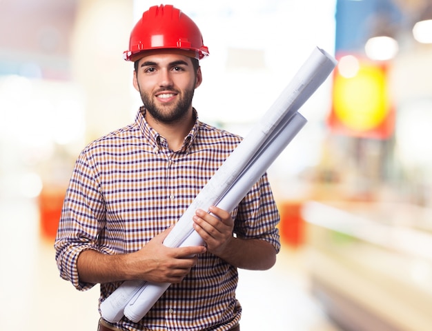 Homem de sorriso com um capacete vermelho e algumas plantas