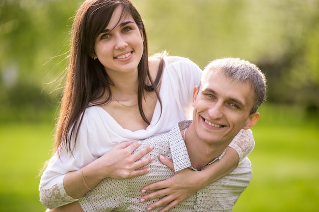 Homem de sorriso que dá o passeio do sobreposto a sua amiga