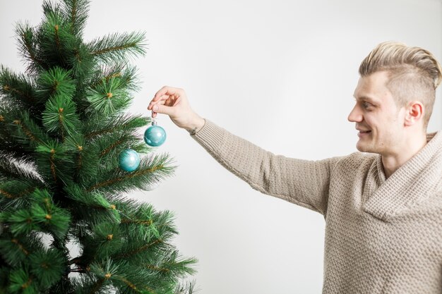 Homem de sorriso que decora a árvore de Natal