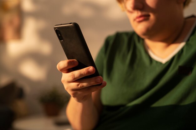 Homem de tamanho grande de vista lateral segurando smartphone