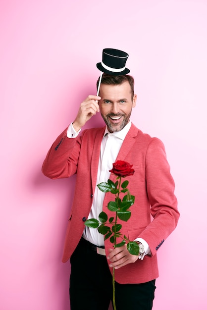 Homem de terno vermelho dando uma rosa