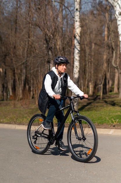 Homem de tiro completo andando de bicicleta ao ar livre