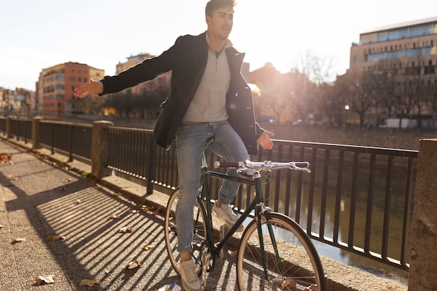 Homem de tiro completo andando de bicicleta na cidade