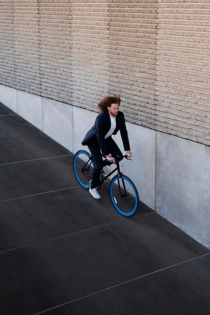 Homem de tiro completo andando de bicicleta para o trabalho