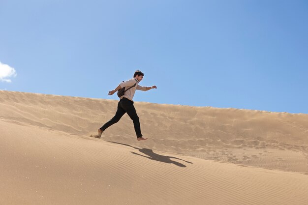 Homem de tiro completo correndo no deserto