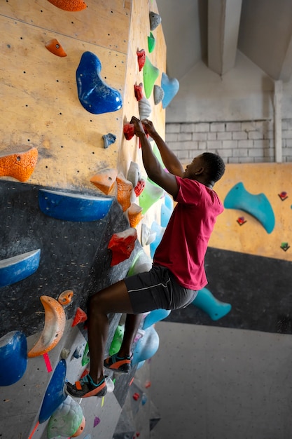 Foto grátis homem de tiro completo escalando a parede