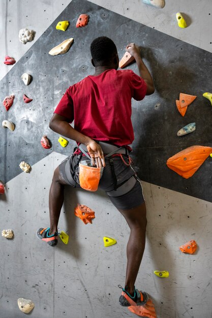 Homem de tiro completo escalando a parede