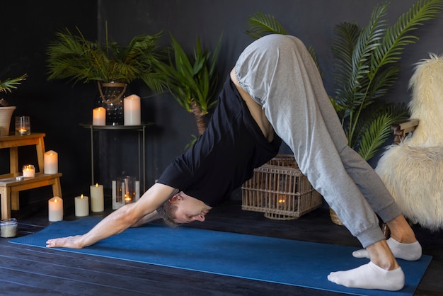 Foto grátis homem de tiro completo fazendo ioga dentro de casa