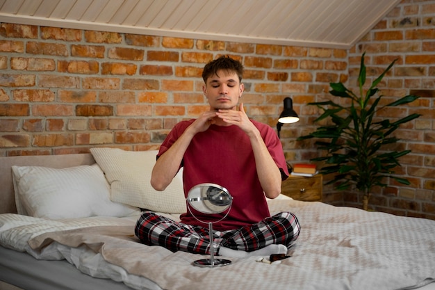 Foto grátis homem de tiro completo massageando o rosto em casa