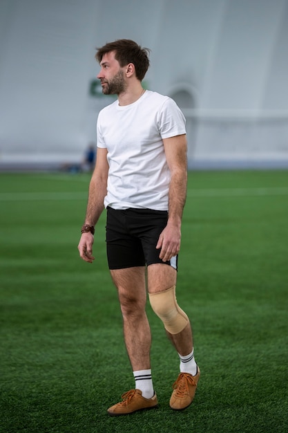 Foto grátis homem de tiro completo no campo de futebol