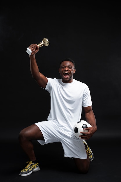 Foto grátis homem de tiro completo segurando o troféu