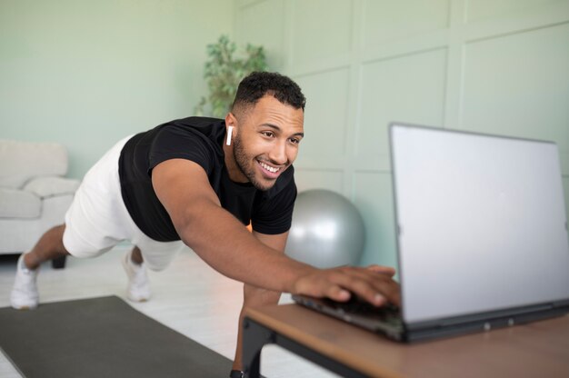 Homem de tiro completo treinando com laptop