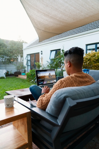 Homem de tiro completo usando laptop ao ar livre