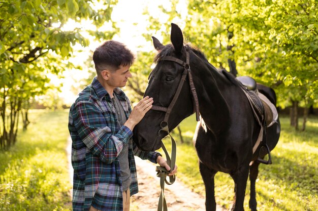 Homem de tiro médio acariciando o cavalo