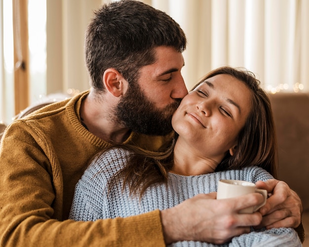 Foto grátis homem de tiro médio beijando mulher na bochecha