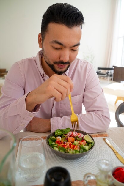 Homem de tiro médio comendo tigela de salmão