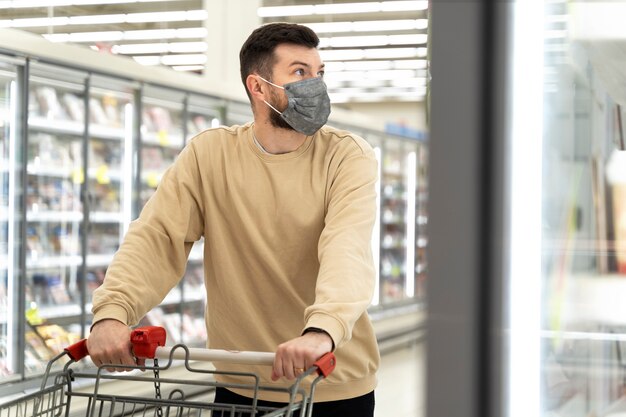 Homem de tiro médio, compras com máscara facial