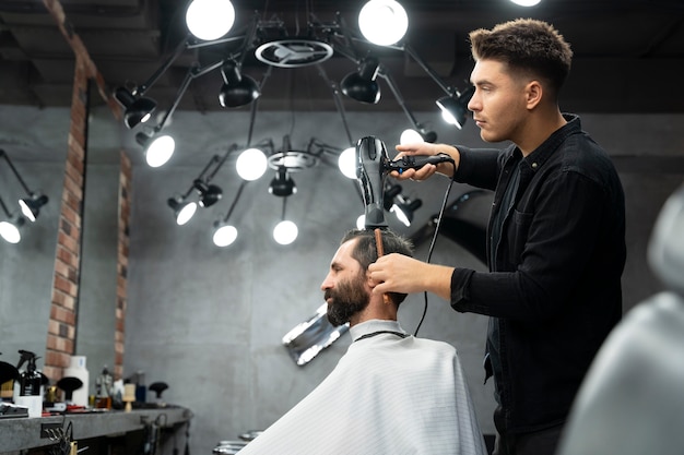 Foto grátis homem de tiro médio cortando o cabelo