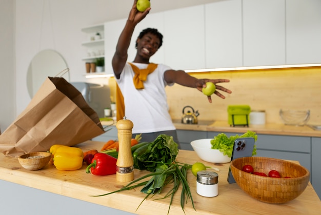 Homem de tiro médio cozinhando com smartphone