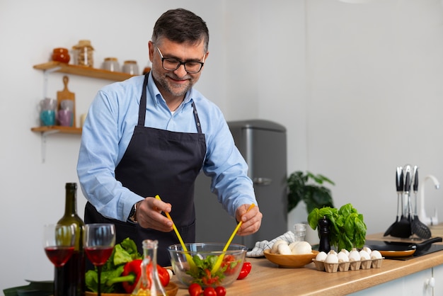 Foto grátis homem de tiro médio cozinhando na cozinha