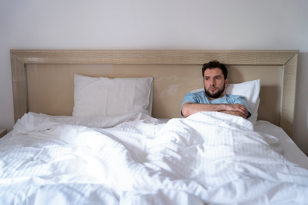 Homem de tiro médio deitado na cama