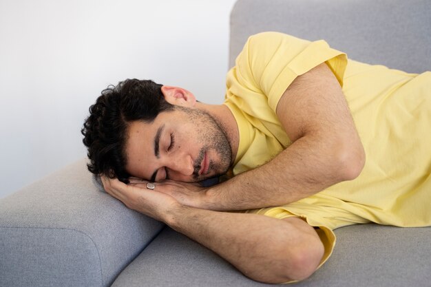 Homem de tiro médio dormindo no sofá