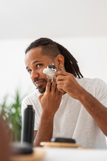 Homem de tiro médio fazendo a barba com creme