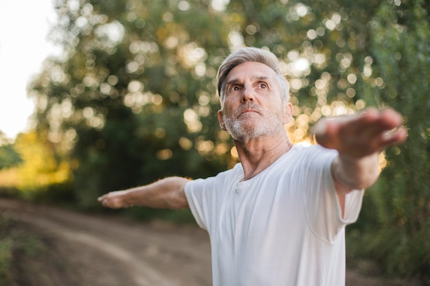 Foto grátis homem de tiro médio fazendo exercícios ao ar livre