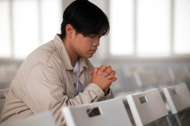 Homem de tiro médio na igreja rezando