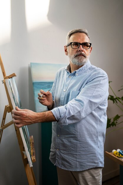 Homem de tiro médio pintando aquarelas