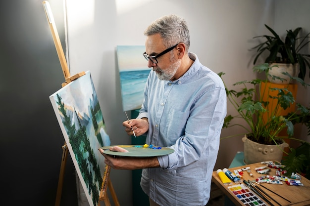 Homem de tiro médio pintando aquarelas