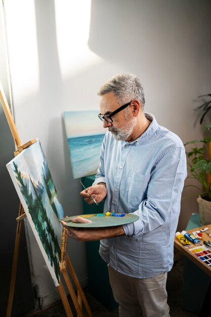 Homem de tiro médio pintando aquarelas