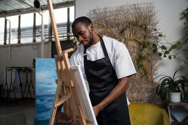 Foto grátis homem de tiro médio pintando aquarelas