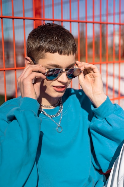 Foto grátis homem de tiro médio posando com óculos de sol e colar