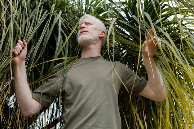 Foto grátis homem de tiro médio posando com planta