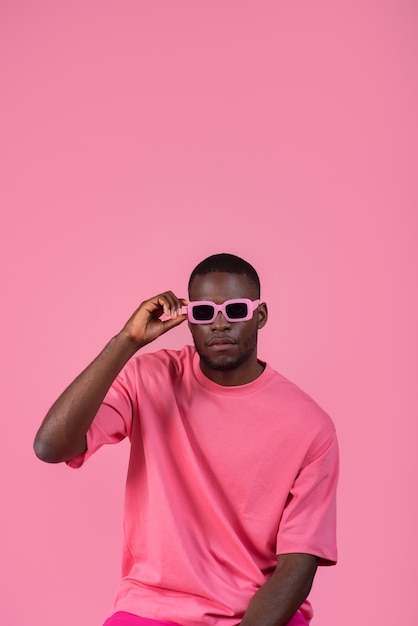 Homem de tiro médio posando com roupa rosa